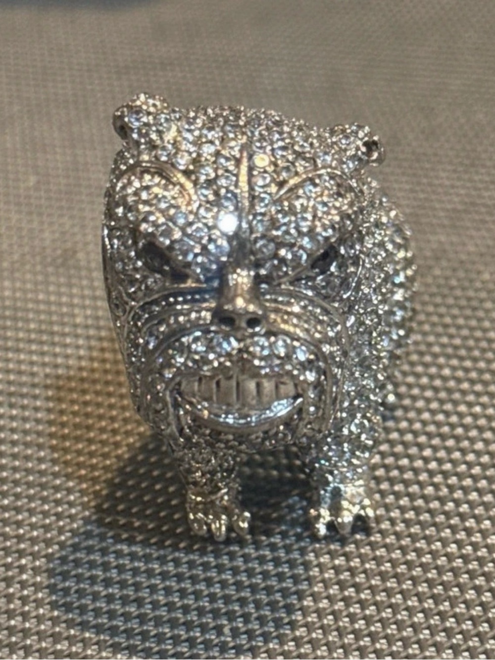 Silver-toned, 3D iced-out bulldog covered in pavé-set synthetic stones.